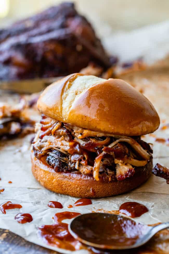 pulled pork made in the oven on a hamburger bun with bbq sauce.