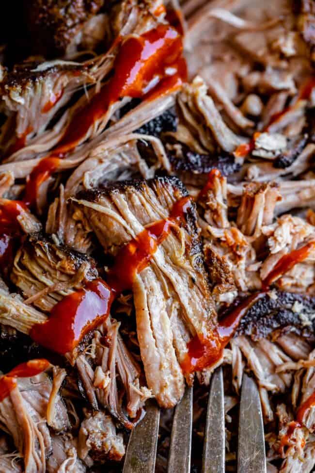 close up of slow cooker pulled pork drizzled with bbq sauce.