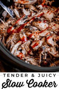 slow cooker pulled pork in a black crock pot with bbq sauce.