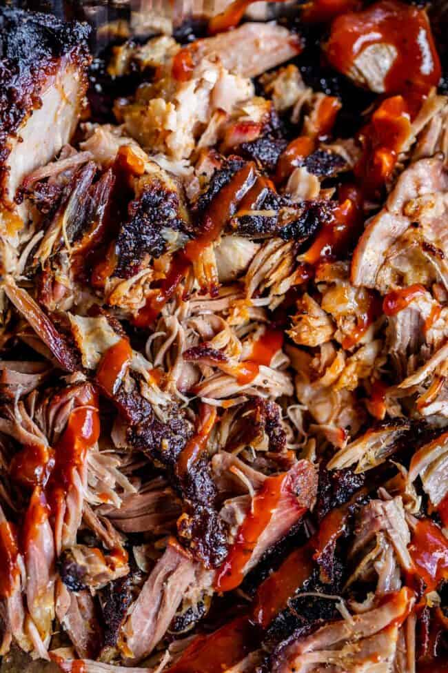 close up of smoked pulled pork drizzled with bbq sauce.