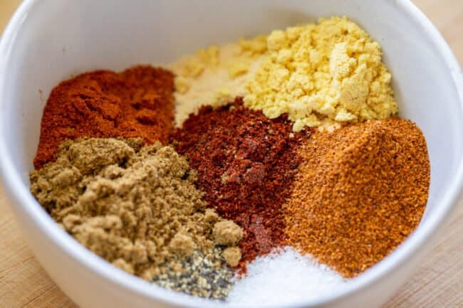 close up of spices in a white bowl.