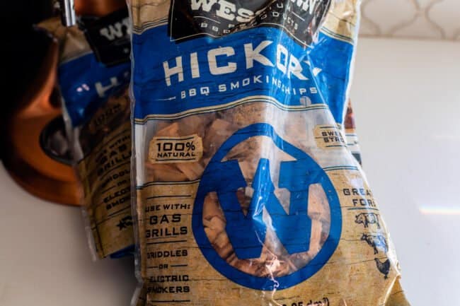 two bags of hickory bbq smoking chips on a white counter.