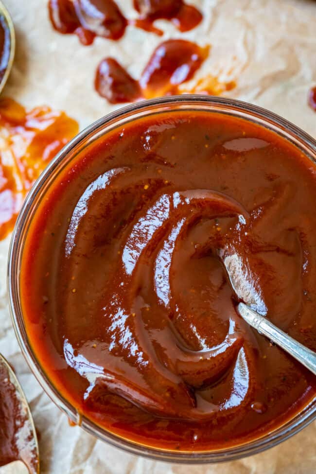 overhead shot of easy bbq sauce in a clear glass bowl on parchment paper.