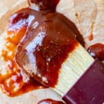 close up of easy bbq sauce on a white brush on parchment paper.