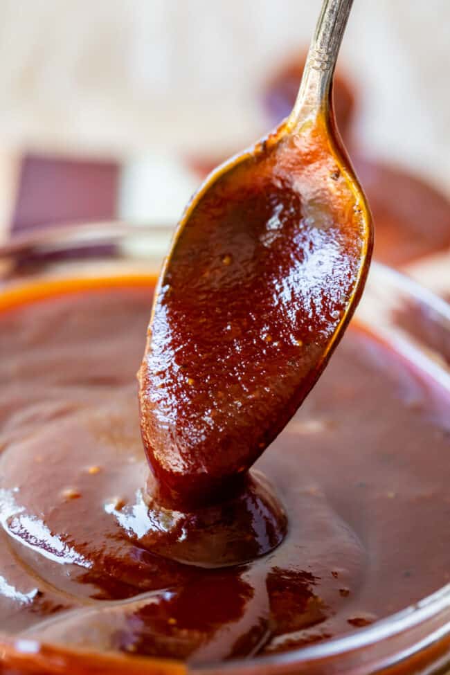 spoon lifting homemade barbecue sauce from a bowl of sauce.