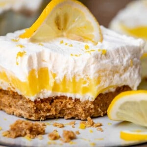 Lemon delight dessert on plate with lemon slices and bite.