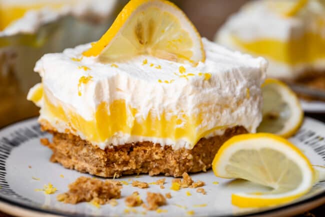 Lemon delight dessert on plate with lemon slices and bite.