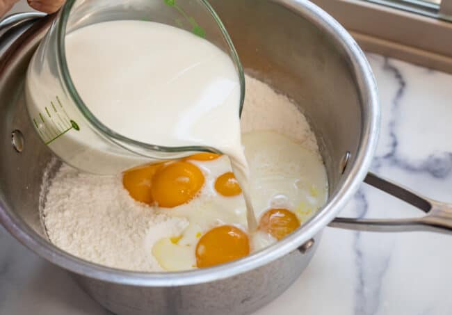 Pouring milk into dough mixture for dessert crust.