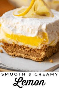 square of lemon lasagna with whipped cream and cream cheese and lemon on plate.