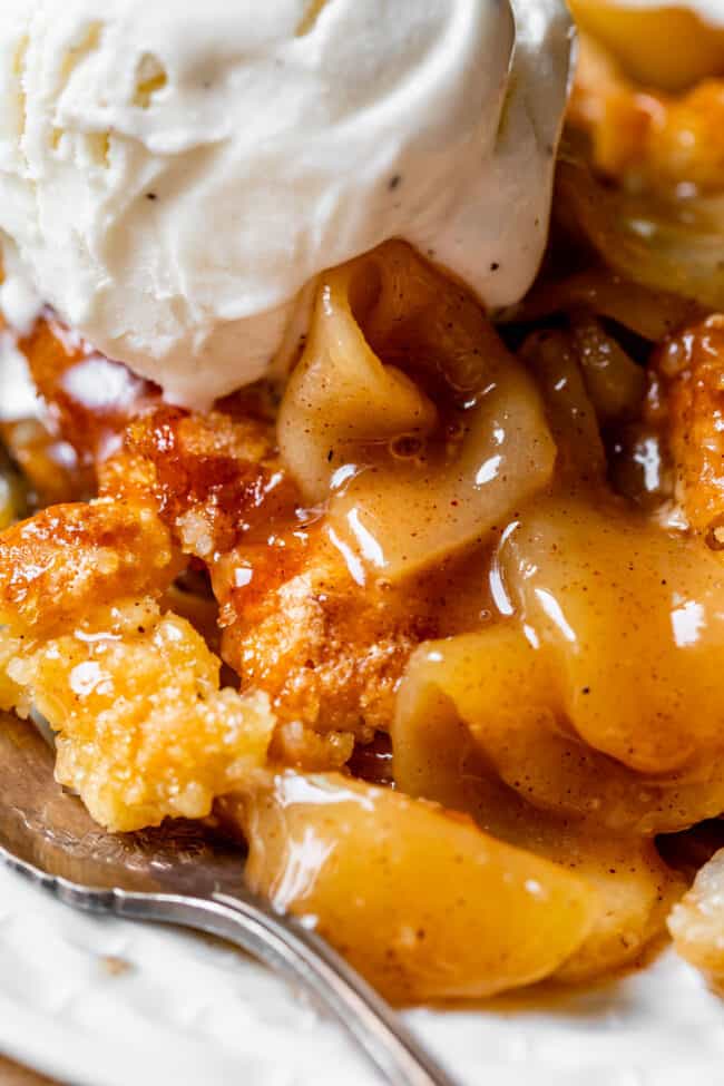 a close up shot of apple cobbler with vanilla ice cream on top.