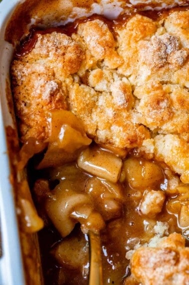 overhead shot of easy apple cobbler in a white dish, with some topping removed.