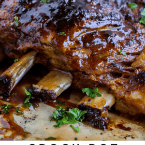 slow cooker ribs with glaze on top, sprinkled with parsley.