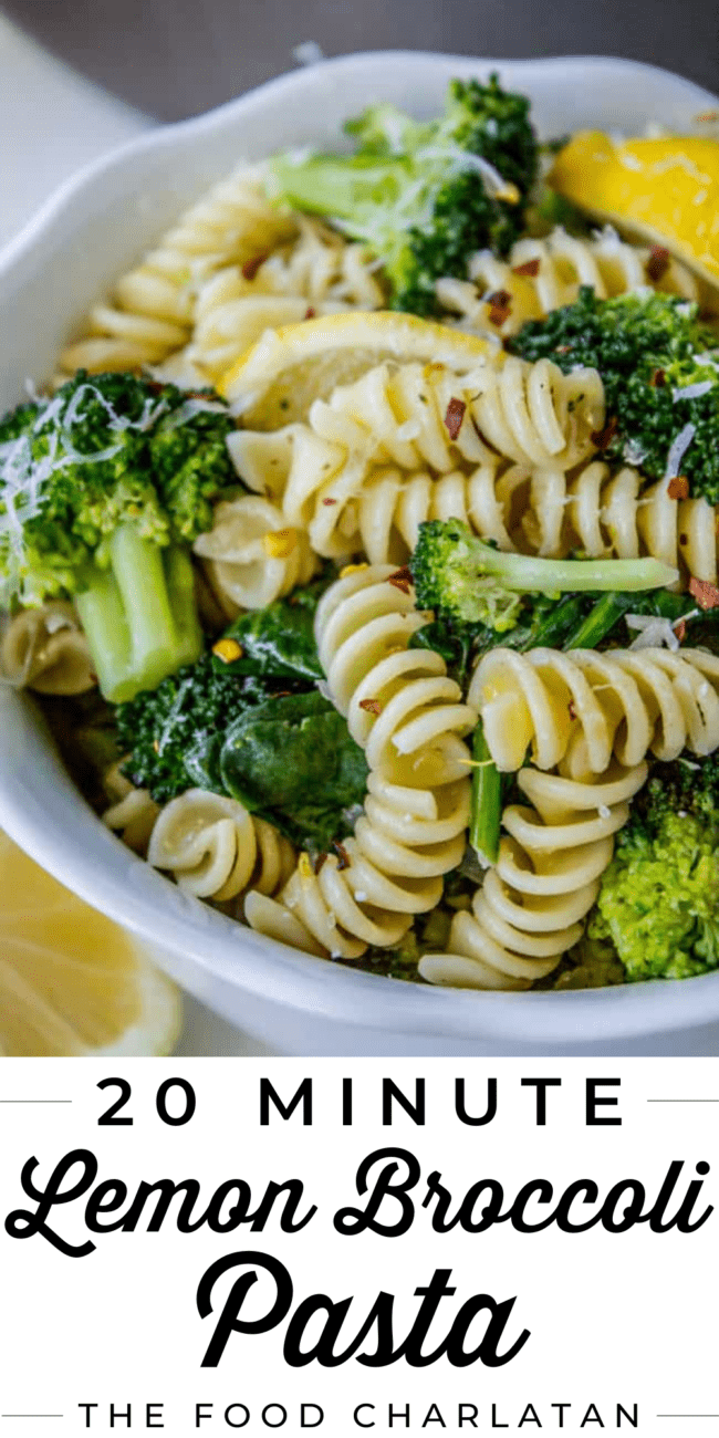 rotini pasta and broccoli in a white bowl with lemon.