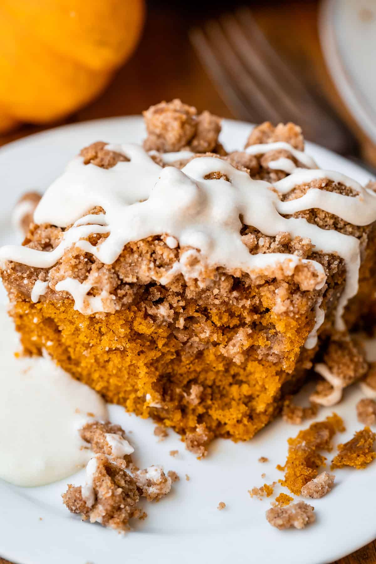 a bite taken out of pumpkin coffee cake recipe on a white plate.