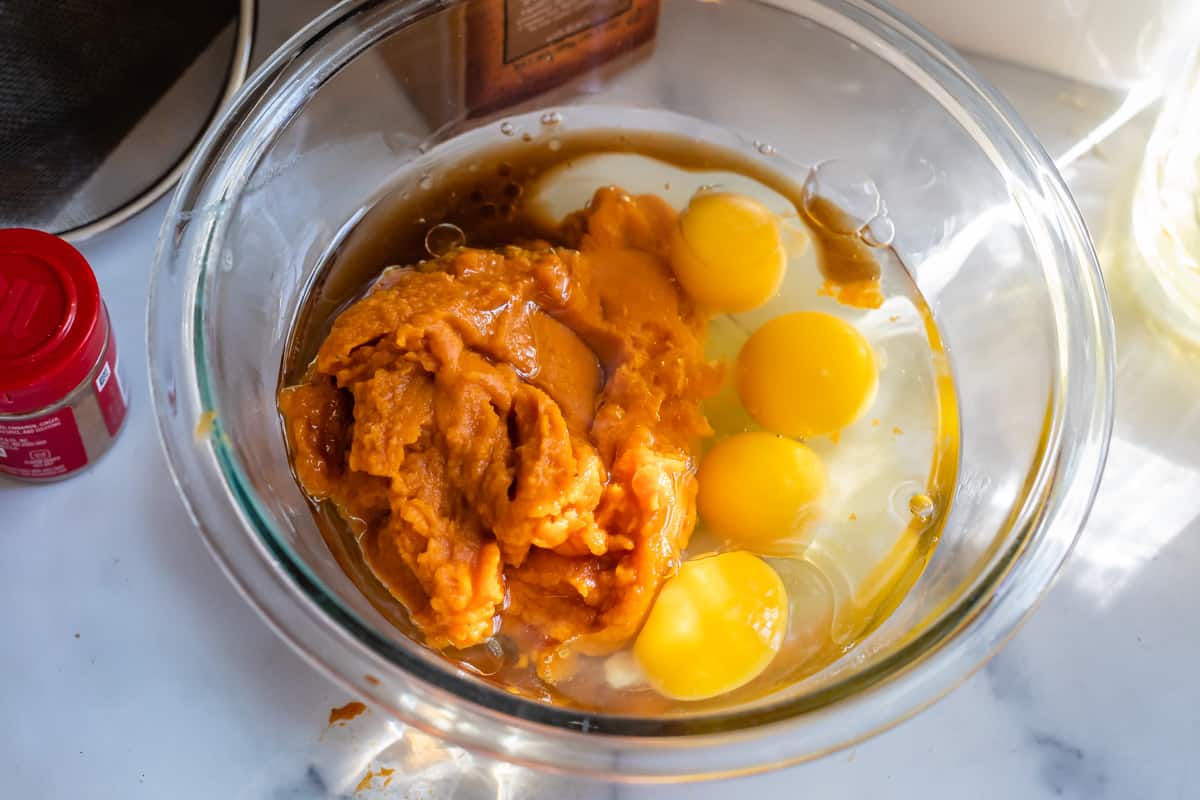 pumpkin, eggs, oil, and vanilla in a glass bowl unmixed.