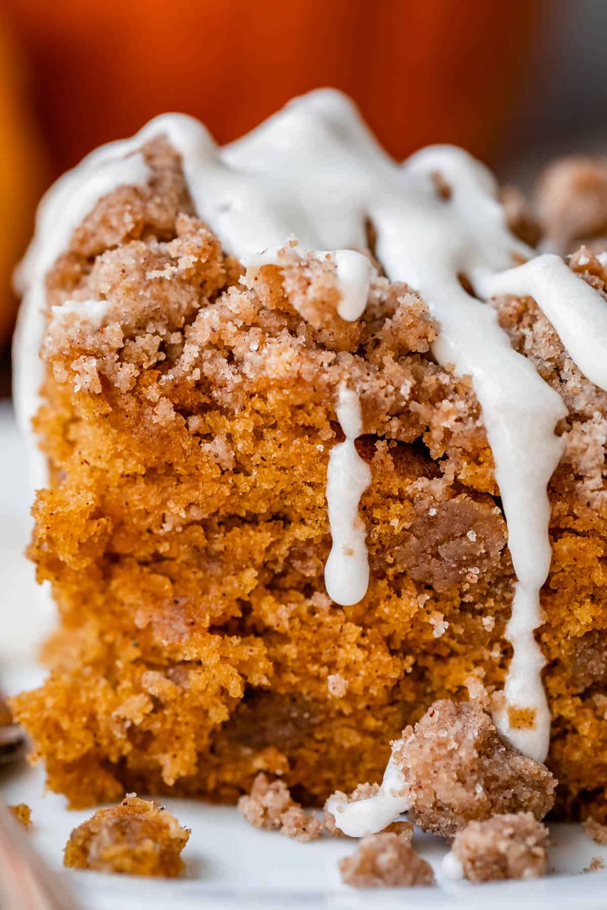 pumpkin coffee cake recipe with glaze dripping down the sides.