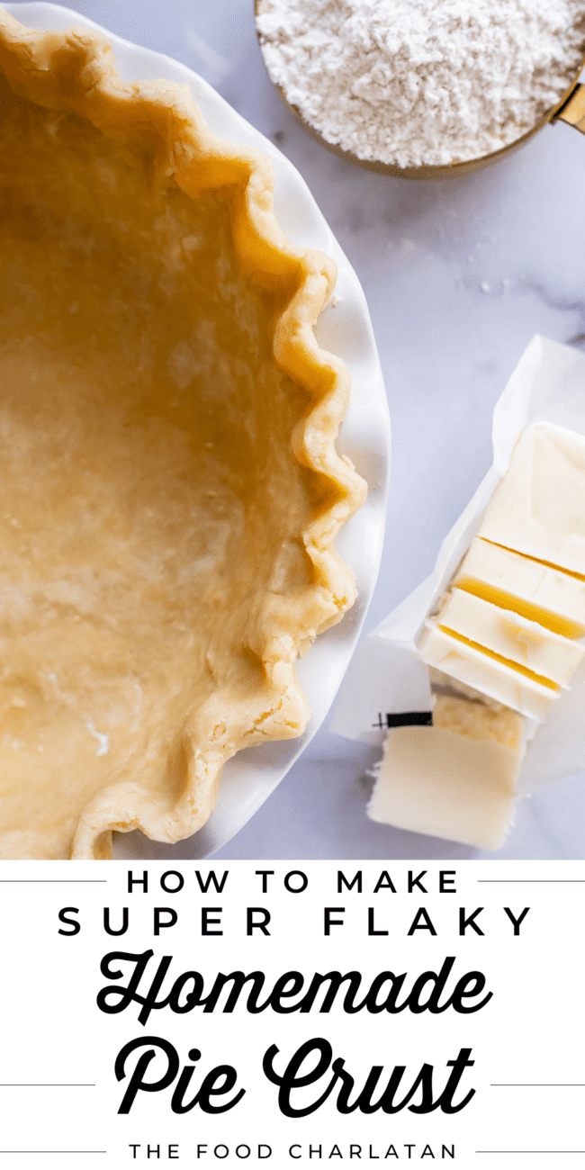flaky homemade pie crust in a pie pan with butter and flour nearby.