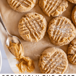 Overhead view of several peanut butter cookies on parchment paper, some with a crosshatch pattern, surrounded by dollops of creamy peanut butter and a jar, with text reading Seriously delicious peanut butter cookies.