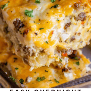 A close-up of a cheesy sausage breakfast casserole being scooped out, topped with chopped parsley. The text reads: “Easy Overnight Sausage Breakfast Casserole — The Food Charlatan.” Perfect for a delicious breakfast spread.
