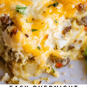 A close-up of a serving of cheesy sausage breakfast casserole topped with chopped parsley, featuring golden melted cheese and visible sausage pieces. Text at the bottom reads: Easy Overnight Sausage Breakfast Casserole.