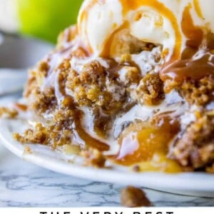 homemade apple crisp with ice cream and caramel on a plate.