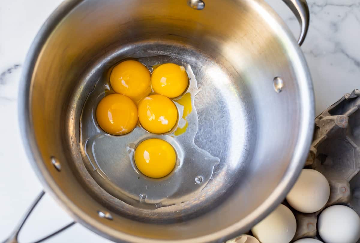 5 egg yolks in a saucepan from overhead.