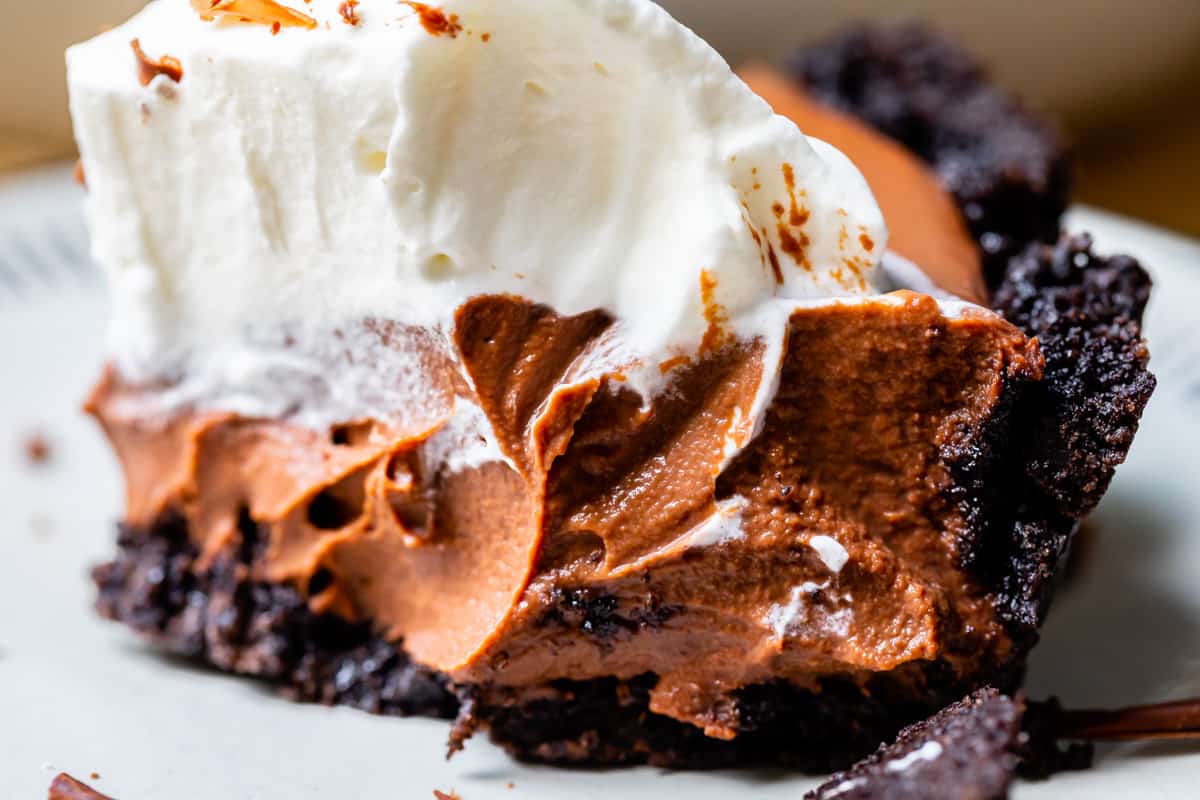 close up shot of chocolate cream pie with whipped cream and Oreo crust.