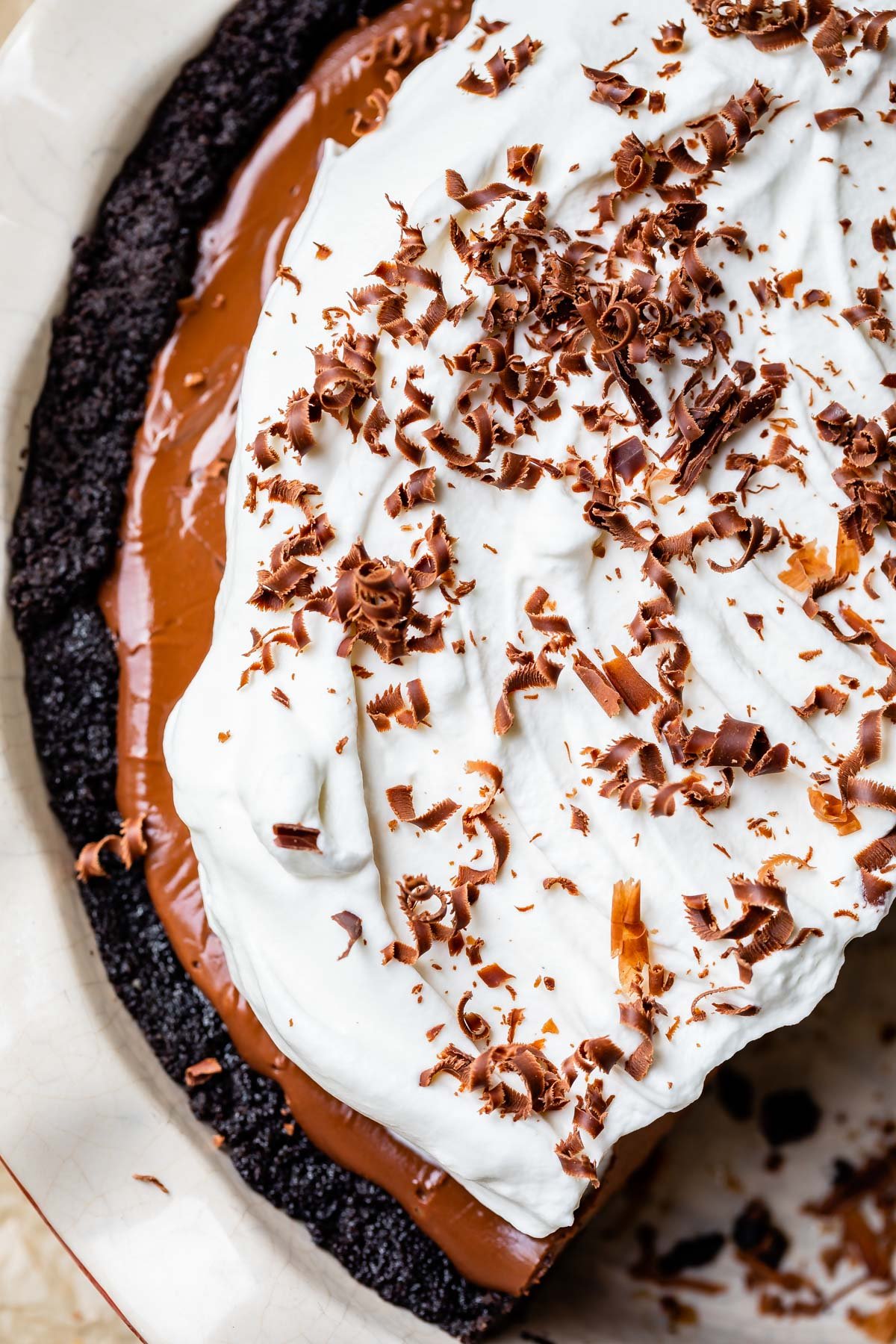 whipped cream topped chocolate cream pie with chocolate shavings.