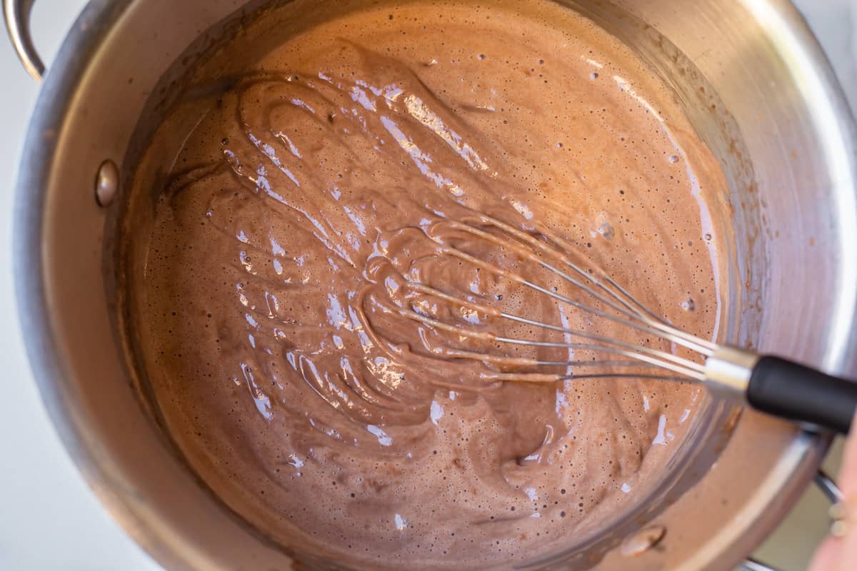 finished pudding in a pot with whisk dragged on top to show lines.