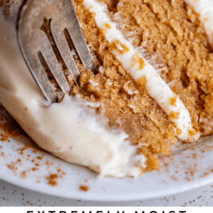 homemade spice cake with cream cheese frosting and a fork.