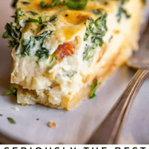 A close-up of a slice of quiche with visible spinach, bacon, and a golden flaky crust, served on a plate with a fork. The text overlay reads, Seriously Delicious Spinach & Bacon Quiche.