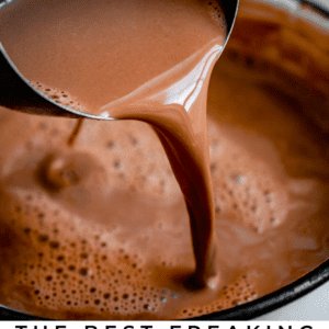 crock pot hot chocolate being poured into a pot from a measuring cup.