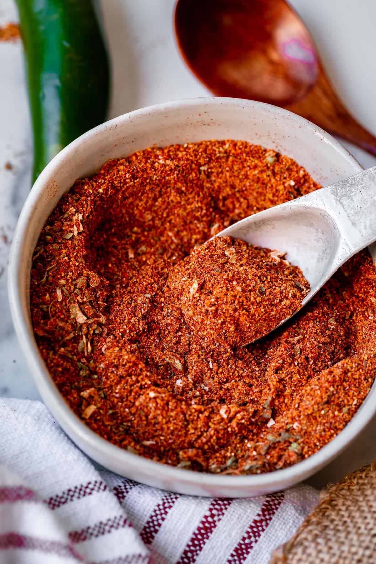 homemade taco seasoning recipe in a white bowl with metal spoon.