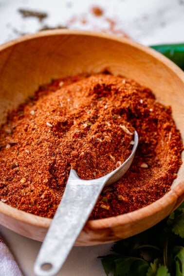 taco seasoning recipe in a wooden bowl with a metal spoon.