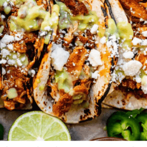 crock pot chicken tacos shot from overhead, with green sauce and white cheese.