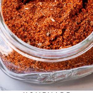 diy taco seasoning in a jar with a wooden spoon.