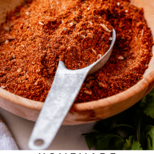 homemade taco seasoning in a wooden bowl with a metal spoon.