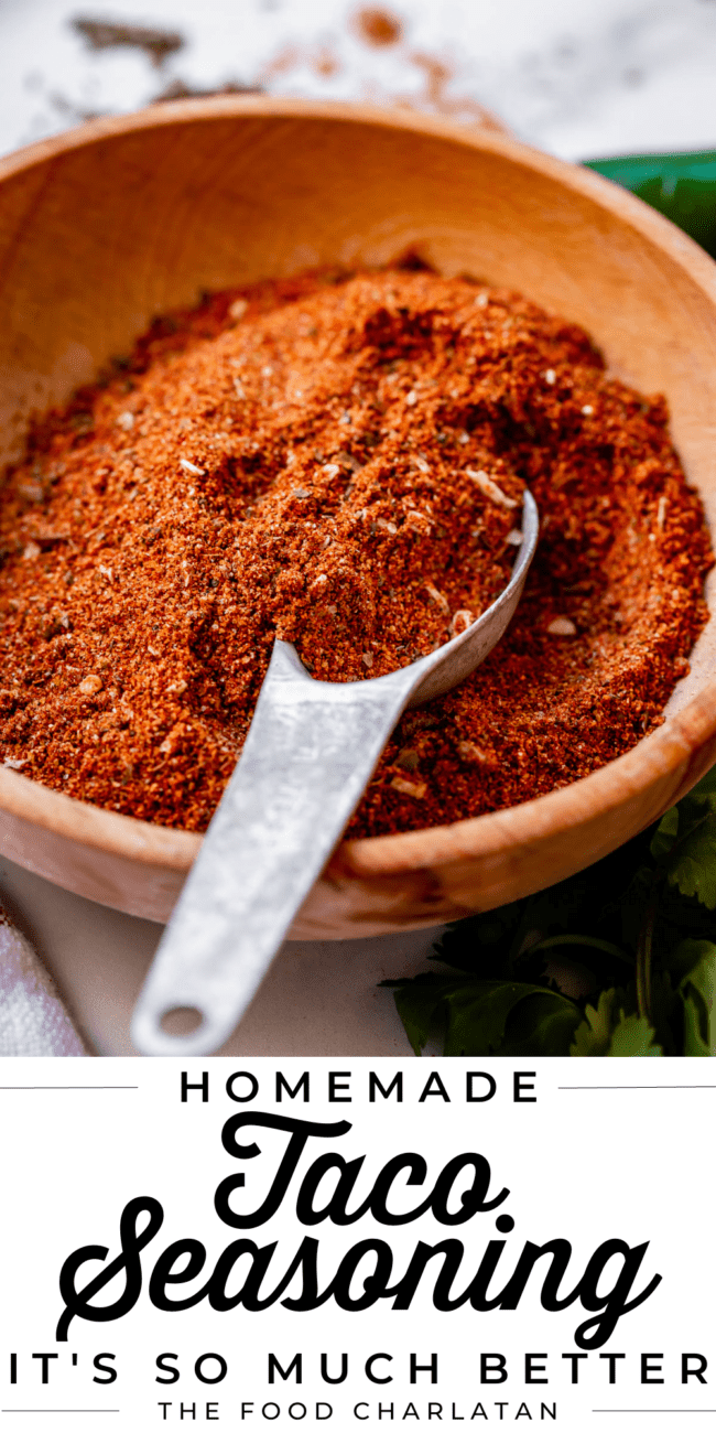 homemade taco seasoning in a wooden bowl with a metal spoon.