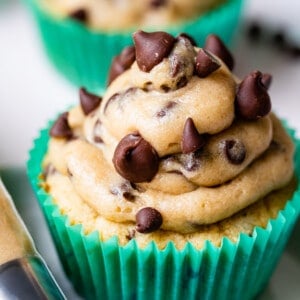cupcakes in green liners with cookie dough frosting and mini chocolate chips.