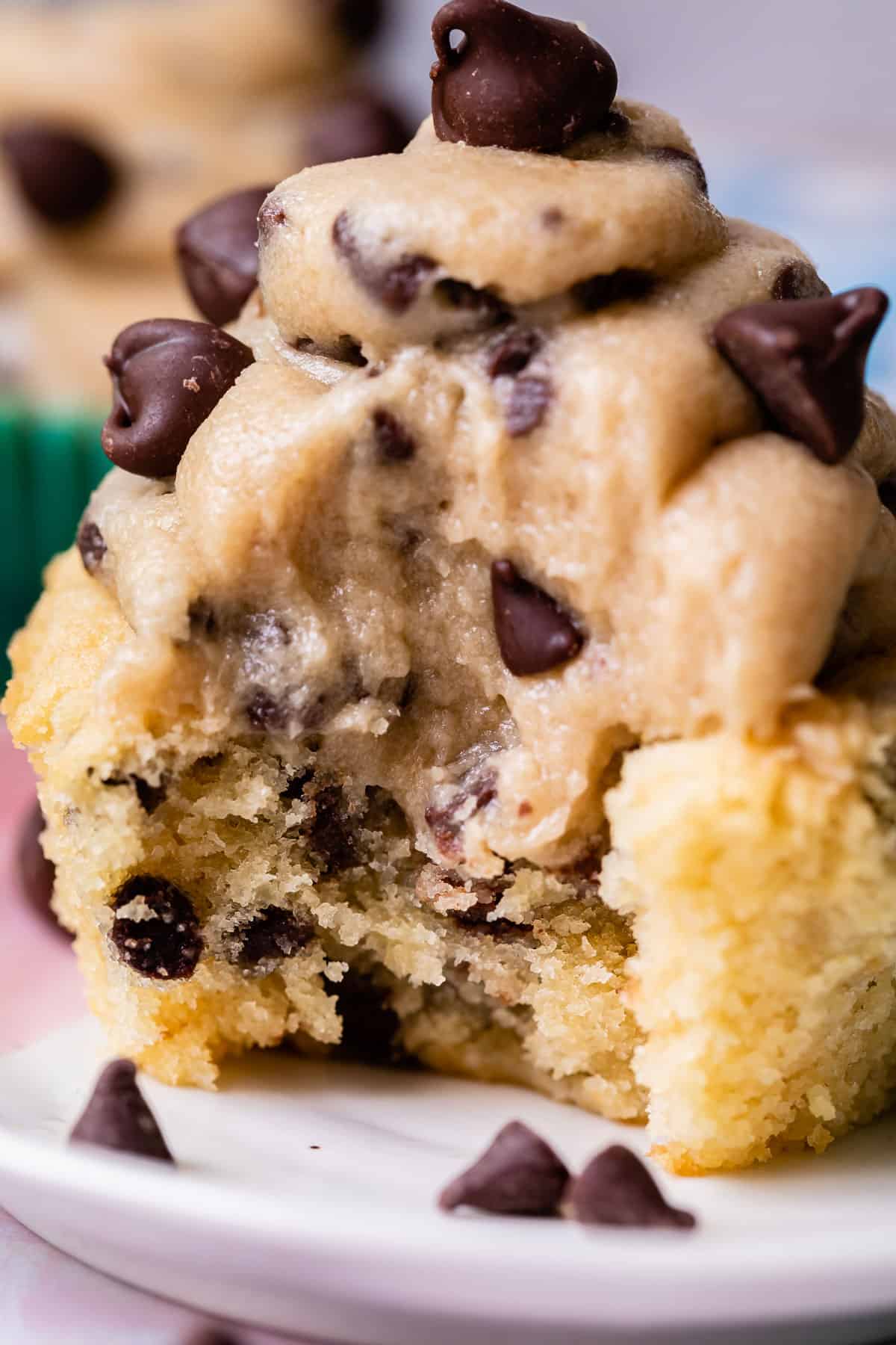 cupcake with mini chocolate chip cookie dough frosting with a bite taken out of it.