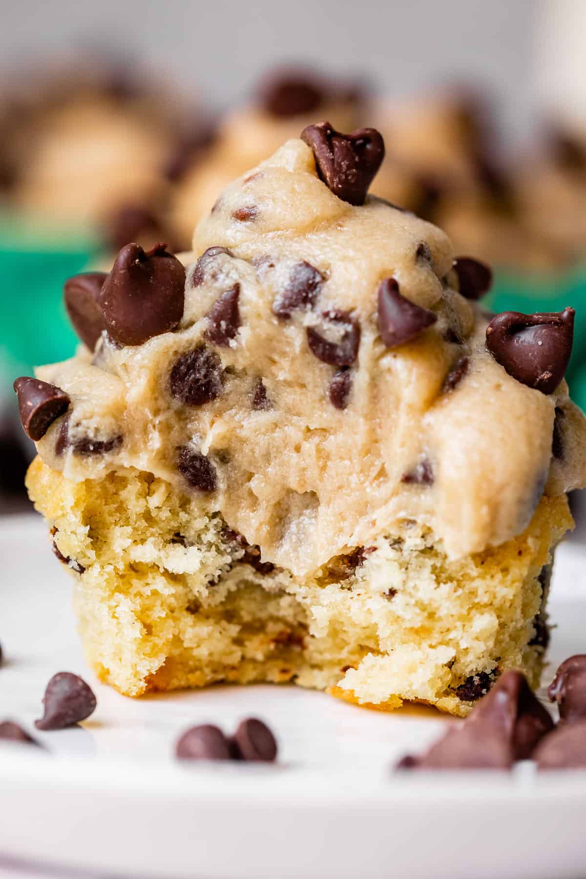 cookie dough frosting on a cookie dough cupcake with a big bite taken out of it.