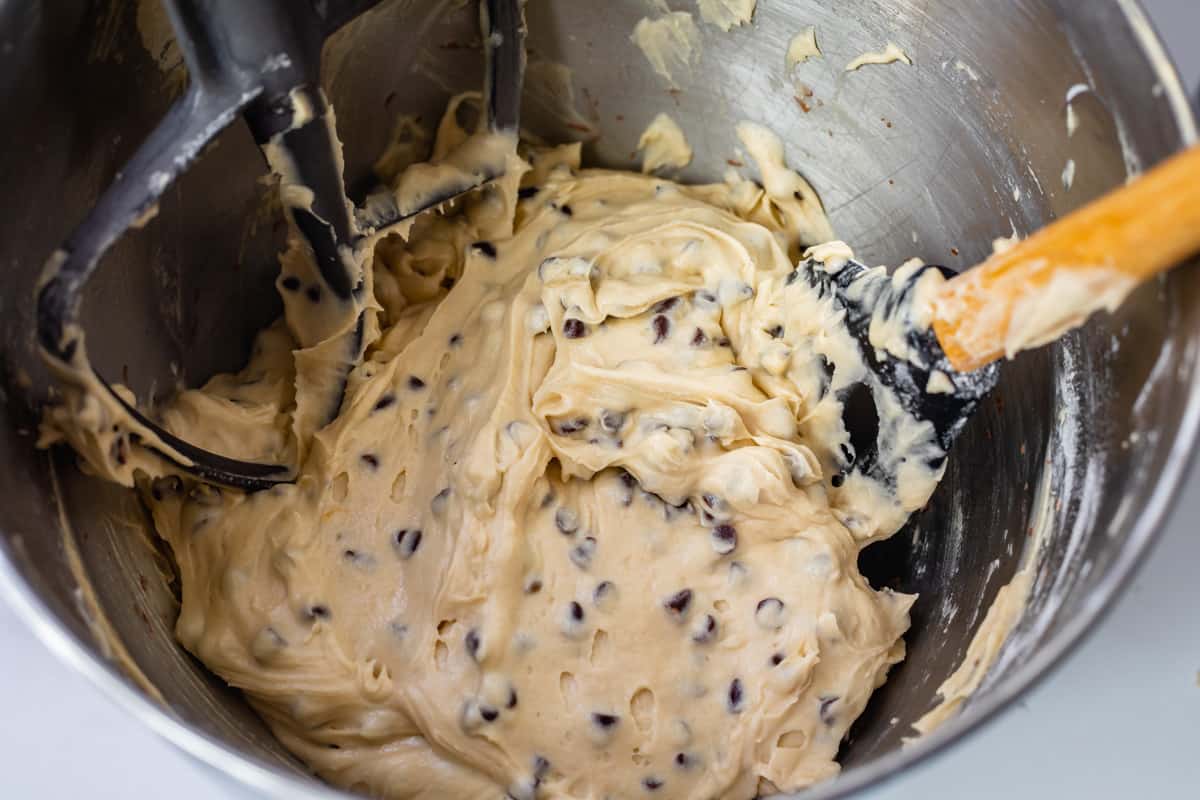 cupcake batter in a stand mixer bowl with mini chocolate chips.