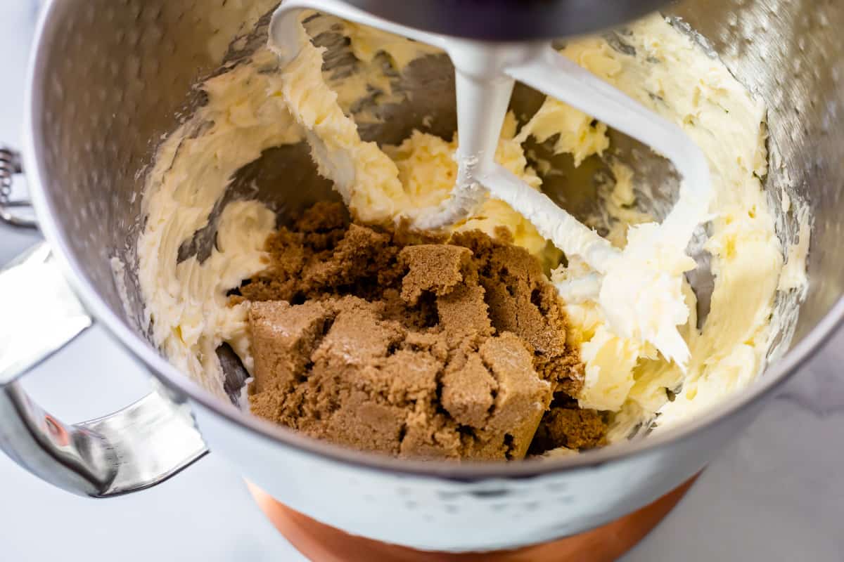 making frosting in a stand mixer with butter, brown sugar, and a paddle attachment.