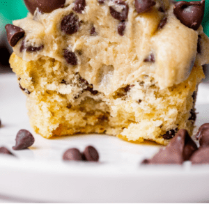 a cupcake with cookie dough frosting with a big bite taken out of it.