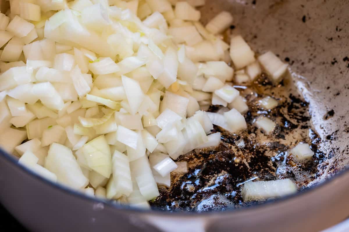 close up of onion frying in blackened meatball drippings.
