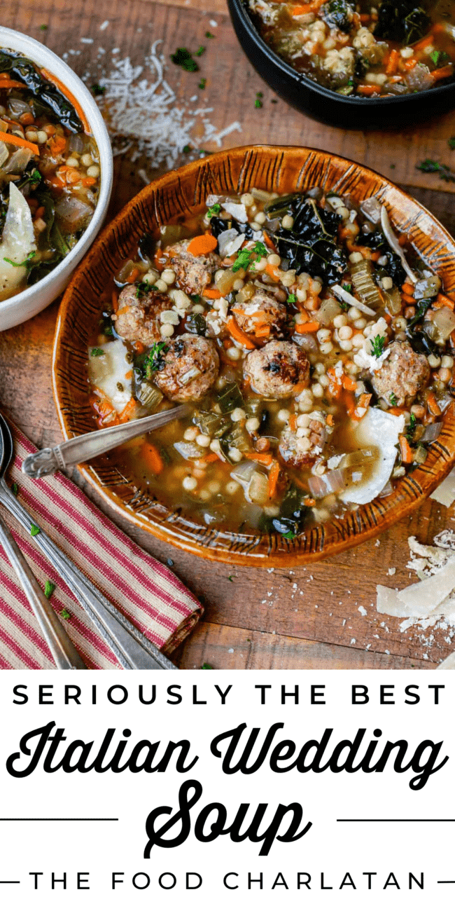 Italian wedding soup in a brown clay bowl with spoon and parmesan cheese.