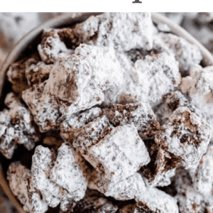 Close-up of a bowl filled with powdered sugar-coated Muddy Buddy snack mix, featuring a text overlay reading Puppy Chow Recipe, a button saying get the recipe, and the website thefoodcharlatan.com at the bottom.