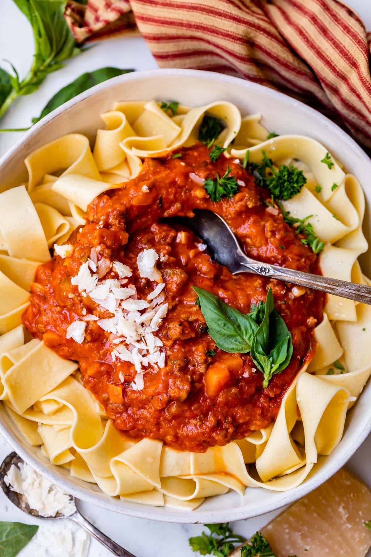 looking down at a bowl with noodles with a large serving of authentic bolognese sauce on top.