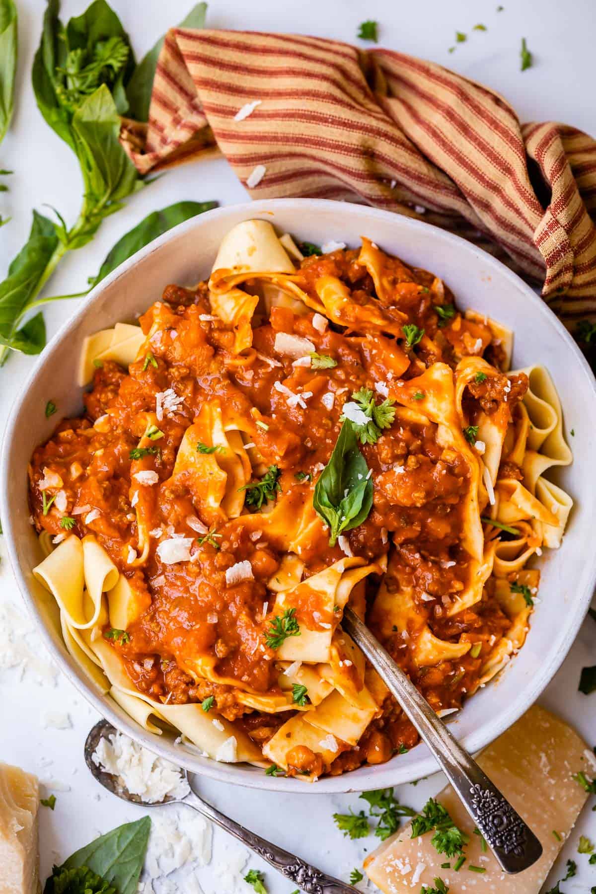 bowl filled with wide noodles topped with homemade bolognese sauce.