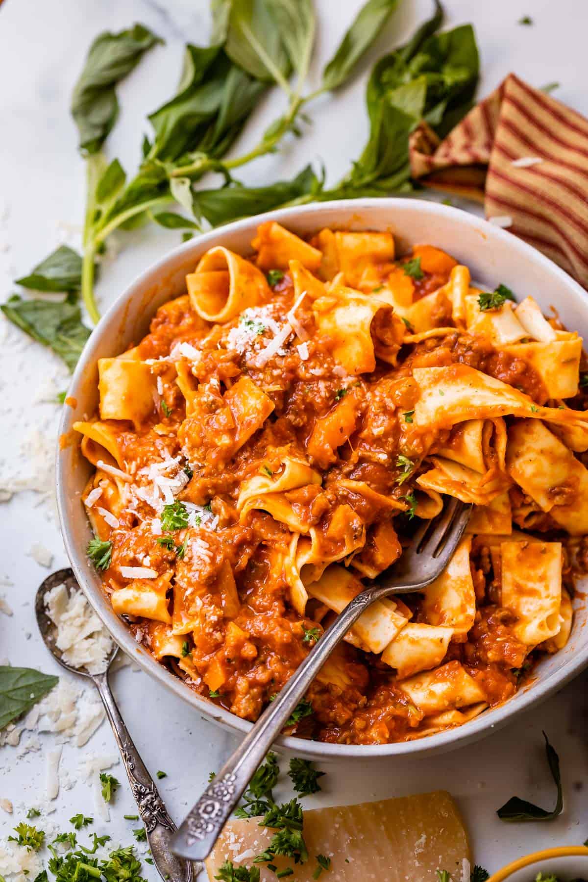 large bowl with a fork stuck in wide noodles covered in easy bolognese sauce.